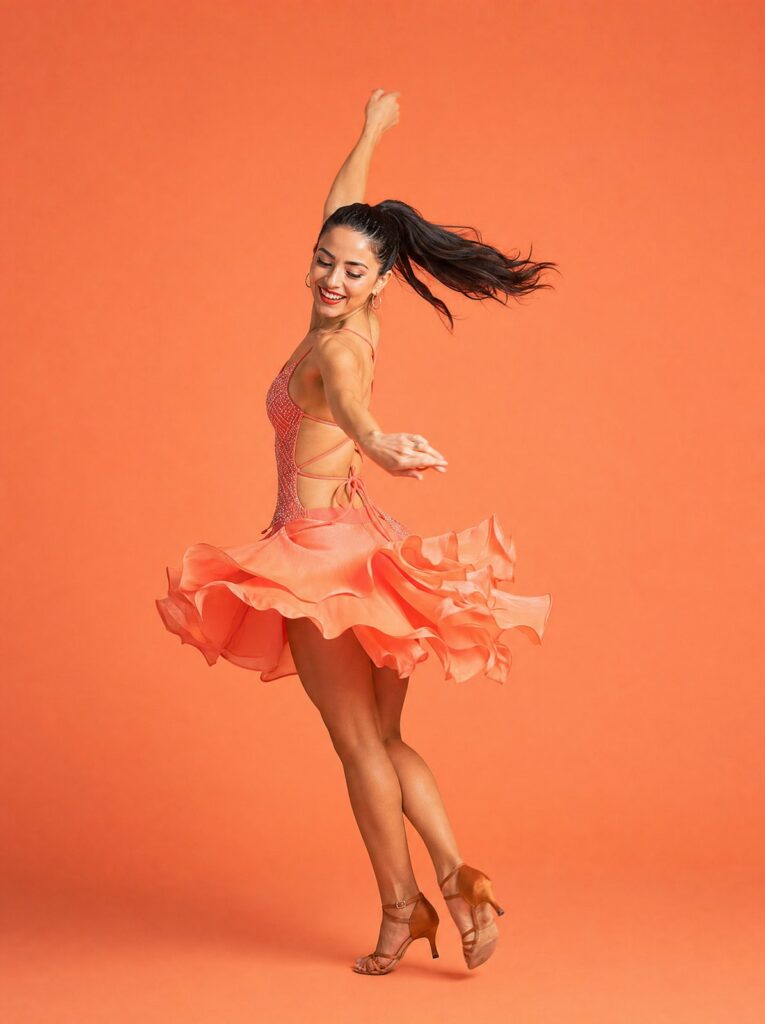 Danseuse latino en robe corail à volants, mouvement de salsa sur fond corail